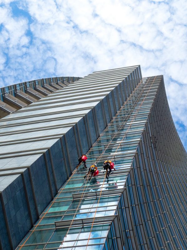 Group of Alpinists in service for windows cleaning of skyscraper